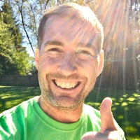 a man in a green shirt giving a thumbs up